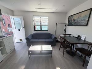 a living room with a couch and a table at Claremont Comfort Cottage in Claremont
