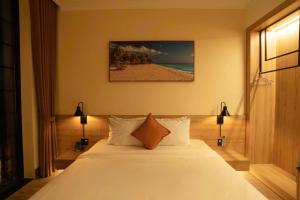 a bedroom with a bed and a picture of a beach at Hotel & Apartment Cong Phung in Ấp Bình Hưng