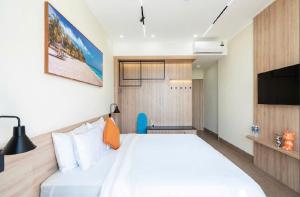 a bedroom with a white bed and a flat screen tv at Hotel & Apartment Cong Phung in Ấp Bình Hưng