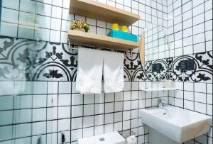 a bathroom with a sink and a white tiled wall at Hotel & Apartment Cong Phung in Ấp Bình Hưng