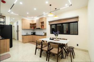 a kitchen and dining room with a table and chairs at Hotel & Apartment Cong Phung in Ấp Bình Hưng