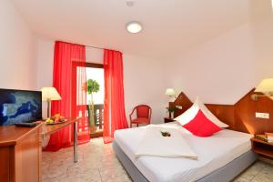 ein Hotelzimmer mit Bett, Schreibtisch und Fernseher in der Unterkunft Hotel am Buchwald in Esslingen + 70 Fotos