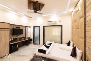 a living room with a bed and a tv at Rath Inns Beach Resort Mandarmani in Mandarmoni