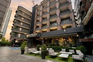 a building with a bunch of chairs in front of it at KTK Pattaya Hotel & Residence in Pattaya