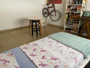 a bedroom with a bed and a table and a bike at La Santiaga Sólo para chicas in Córdoba