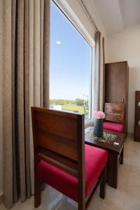 a room with a table and a large window at The WoodLuck Zirakpur Chandigarh - Sidham Group of Hotels in Chandīgarh