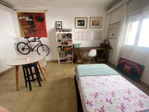 a bedroom with a bed and a table and a bike at La Santiaga Sólo para chicas in Córdoba +7 photos