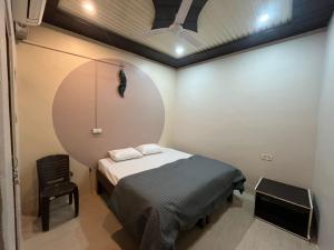 a small room with a bed and a chair at Yovibe Stays, Dorms & Rooms, Assi Ghat, Varanasi in Varanasi