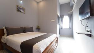 a bedroom with a bed and a flat screen tv at MM Hotel Grey Luxury in Coimbatore
