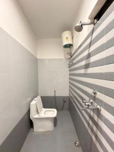 a bathroom with a white toilet and a sink at Yovibe Stays, Dorms & Rooms, Assi Ghat, Varanasi in Varanasi