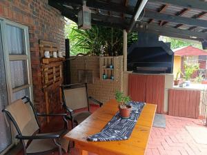 a wooden table with a potted plant on a patio at SMAPERS GUESTHOUSE in Brits