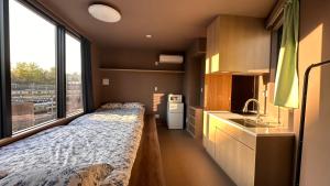 a bedroom with a bed and a large window at WINN hotel in Tokyo