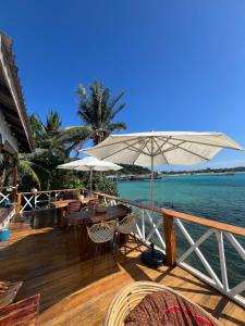 a wooden deck with tables and umbrellas on the water at Deja Vu Bungalows in Kaôh Rŭng (3)