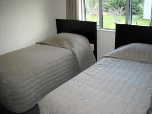 1 Schlafzimmer mit 2 Einzelbetten und einem Fenster in der Unterkunft St Johns court motel in Milton