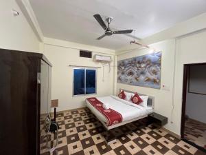 a bedroom with a bed and a ceiling fan at Hotel PSR INN in Mughal Sarāi