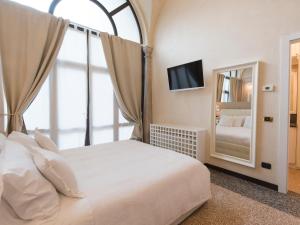 een slaapkamer met een groot bed en een spiegel bij Suite Prestige Verona in Verona