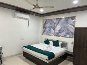 a bedroom with a bed with a large painting on the wall at Hotel PSR INN in Mughal Sarāi