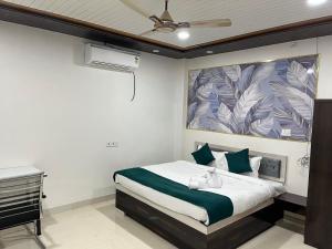 a bedroom with a bed and a ceiling fan at Hotel PSR INN in Mughal Sarāi