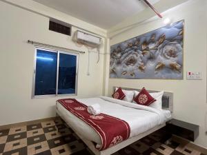 a bedroom with a bed with a painting on the wall at Hotel PSR INN in Mughal Sarāi