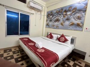a bedroom with a bed with a painting on the wall at Hotel PSR INN in Mughal Sarāi +18 photos