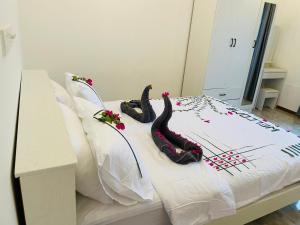 a bed with three black flamingos laying on it at White Tern Maldives in Fenfushi