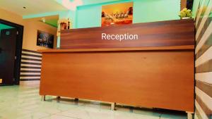 a reception desk in a lobby with the word reception at Hotel Dipak in Himatnagar