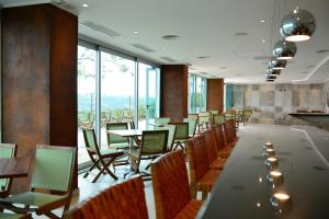 伊瓜蘇港的住宿－Hotel Guaminí Misión，用餐室配有桌椅和大窗户