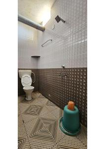 a bathroom with a toilet and a green container on the floor at Netrani Residency in Māvalli +21 photos