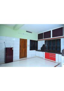 a large empty room with a kitchen with at Netrani Residency in Māvalli