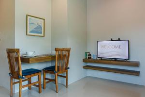 two chairs and a television in a room at Happy Eight Resort in Nai Harn Beach