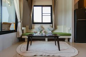 a living room with a table and a green couch at Happy Eight Resort in Nai Harn Beach