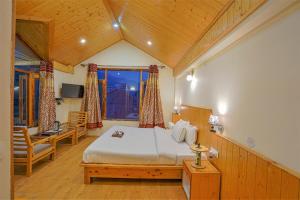 a bedroom with a large bed and a window at Pine Wood Chalet in Manāli