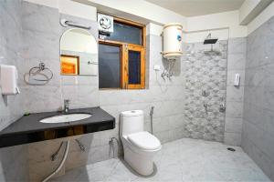 a bathroom with a toilet and a sink and a mirror at Pine Wood Chalet in Manāli +114 photos