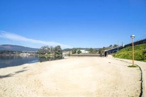 a sandy beach next to a body of water at O piso da Tia Lo,la in Sotomayor