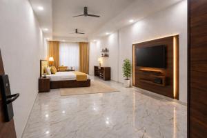 a bedroom with a bed and a flat screen tv at The Royal Height in Nawāda