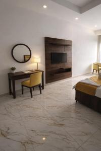 a bedroom with a bed and a desk and a mirror at The Royal Height in Nawāda