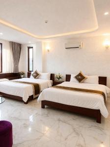 a hotel room with two beds in a room at White Rose Hotel in Dong Hoi