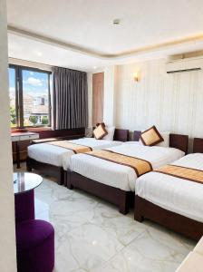 a hotel room with three beds and a table at White Rose Hotel in Dong Hoi +25 photos