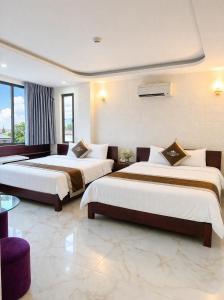 a hotel room with two beds in a room at White Rose Hotel in Dong Hoi