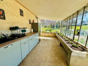 a kitchen with a bench in a room with windows at Le Pavillon, Grand Manoir du XVIIe avec Piscine, Bain Nordique et accès privé à la Charente in Alloué