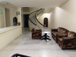 a hallway with two couches and a table and a staircase at Hotel Marble Palace in Khajurāho