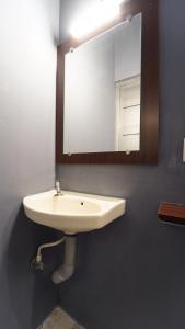 a bathroom with a white sink and a mirror at MM Hotel Grey Luxury in Coimbatore +15 photos