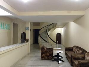 a hallway with two chairs and a spiral staircase at Hotel Marble Palace in Khajurāho +35 photos