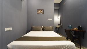 a bedroom with a bed and a table with a desk at MM Hotel Grey Luxury in Coimbatore