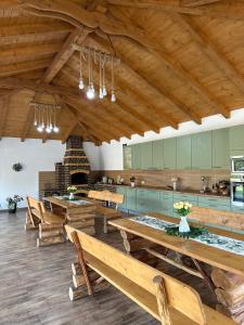 a large room with wooden tables and a kitchen at Povestea din Munti in Arpaşu de Sus