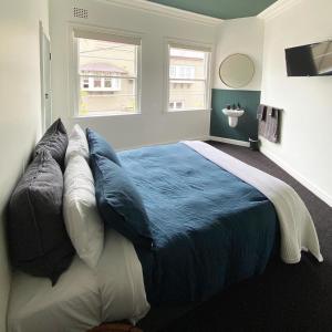a bedroom with a large bed with blue sheets and pillows at Blues Point Hotel in Sydney +5 photos