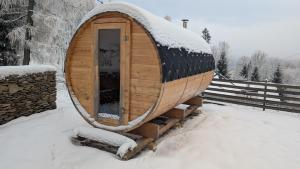 a wooden hobbit house in the snow at Martinova bouda in Benecko