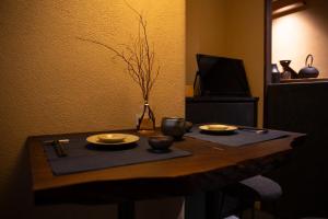 a table with two plates and a vase on it at modern villa, asterisk ONOMICHI 2 in Onomichi