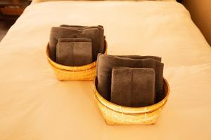two baskets sitting on top of a bed at modern villa, asterisk ONOMICHI 2 in Onomichi