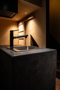 a kitchen counter with a sink and a faucet at modern villa, asterisk ONOMICHI 2 in Onomichi +29 photos